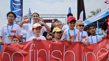 A group of children hold a banner that reads